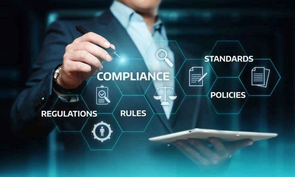 Image of person holding a tablet and pen with words compliance, standards, policies, rules, and regulations.